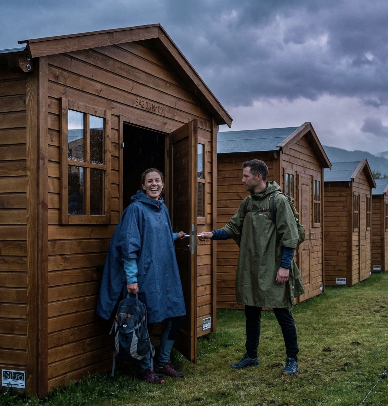 Gäste kommen bei Regen am Holzchalet an — trocken und warm