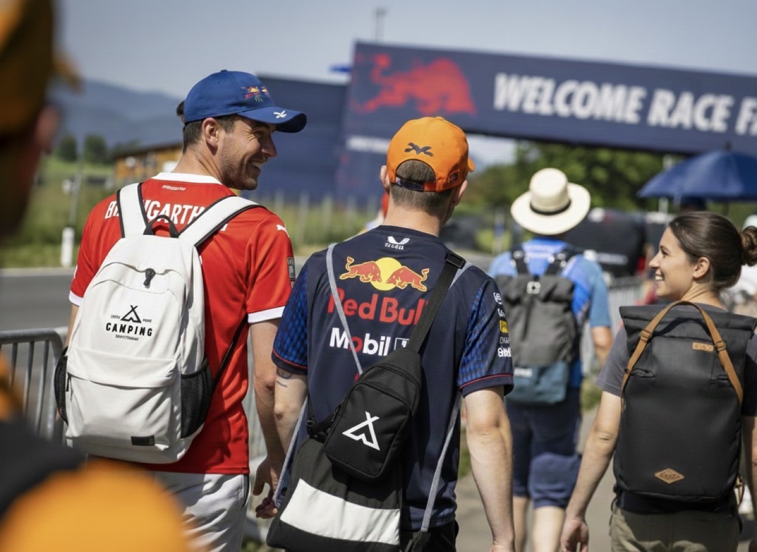 Gäste gehen die 900 m vom Campingplatz zum Red Bull Ring — mit Schitterhof-CAMPING-Rucksack